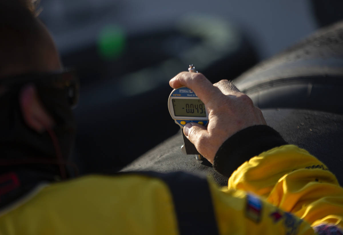 A member of Michael McDowell's (34) pit crew checks tire pressure during a NASCAR Cup Seri ...