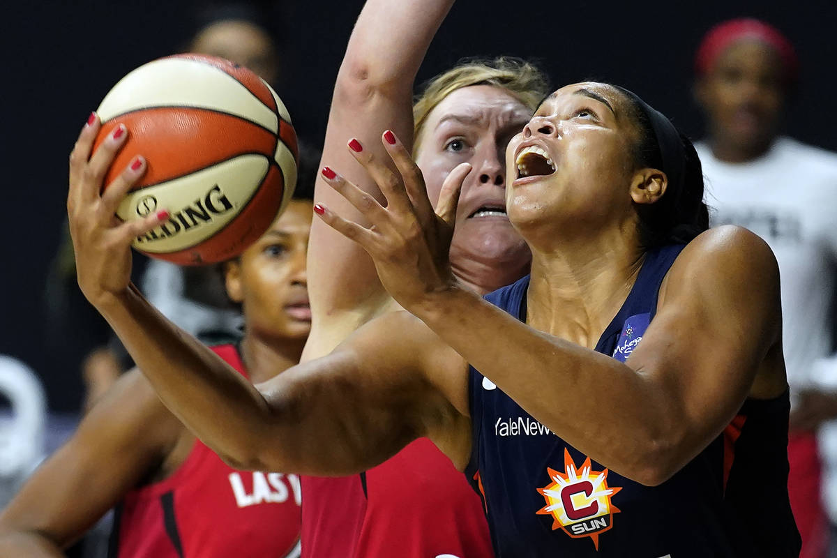 Connecticut Sun center Brionna Jones (42) goes up for a shot while being guarded by Las Vegas A ...
