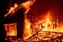 Flames from the Glass Fire consume a vineyard building in St. Helena, Calif., on Sunday, Sept. ...