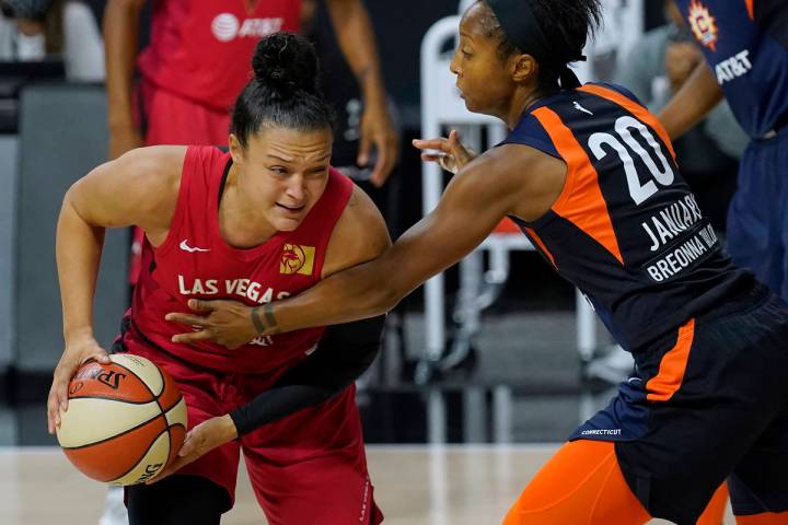 Connecticut Sun guard Briann January (20) fouls Las Vegas Aces guard Kayla McBride (21) during ...