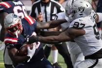 New England Patriots running back Sony Michel (26) tries to break free from Las Vegas Raiders d ...
