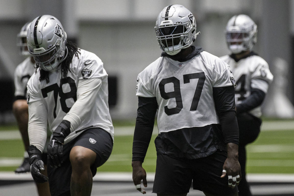 Raiders defensive tackle Maliek Collins (97) stretches during an NFL football training camp pra ...