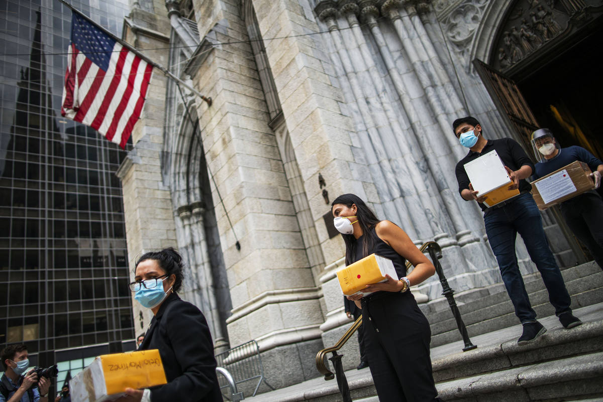 FILE - In this July 11, 2020, file photo, mourners carry out the remains of loved ones followin ...