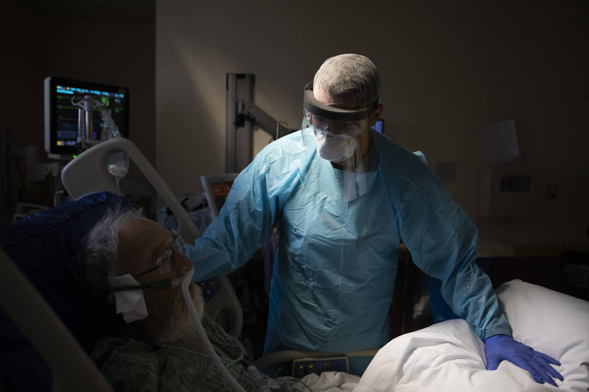 FILE - In this July 7, 2020, file photo, Spencer Cushing, 29, tends to David Feinour, a 71-year ...