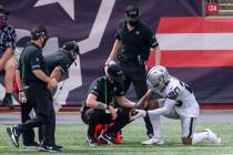 Las Vegas Raiders cornerback Damon Arnette (20) has his right wrist looked at by trainers and h ...
