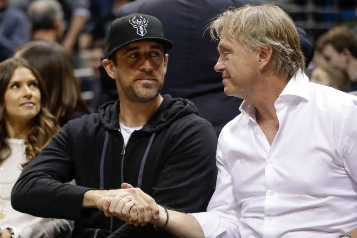 Milwaukee Bucks owner Wes Edens and Green Bay Packers' Aaron Rodgers watch during the first hal ...