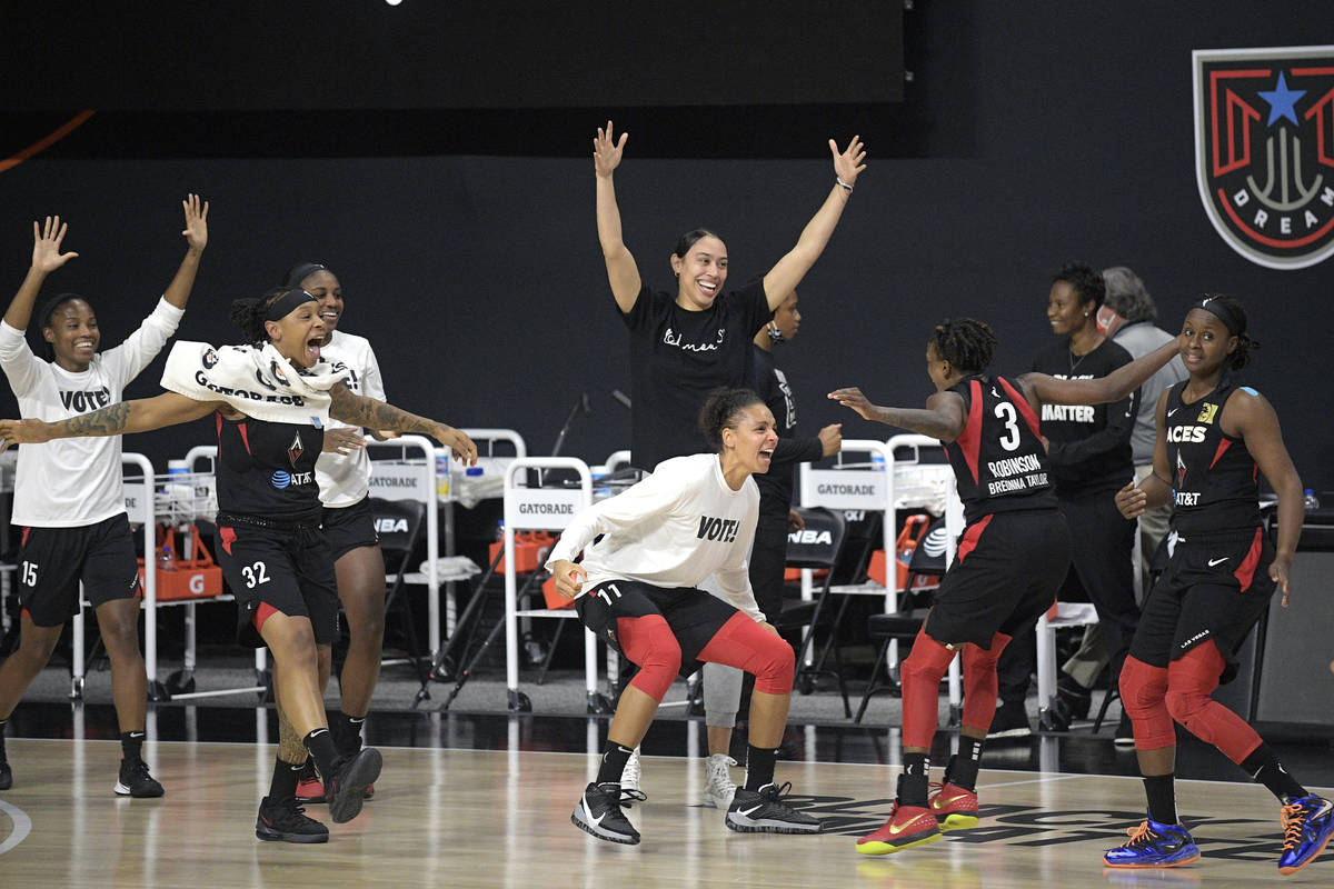 Las Vegas Aces players celebrate after getting the win over the Connecticut Sun in Game 5 of a ...
