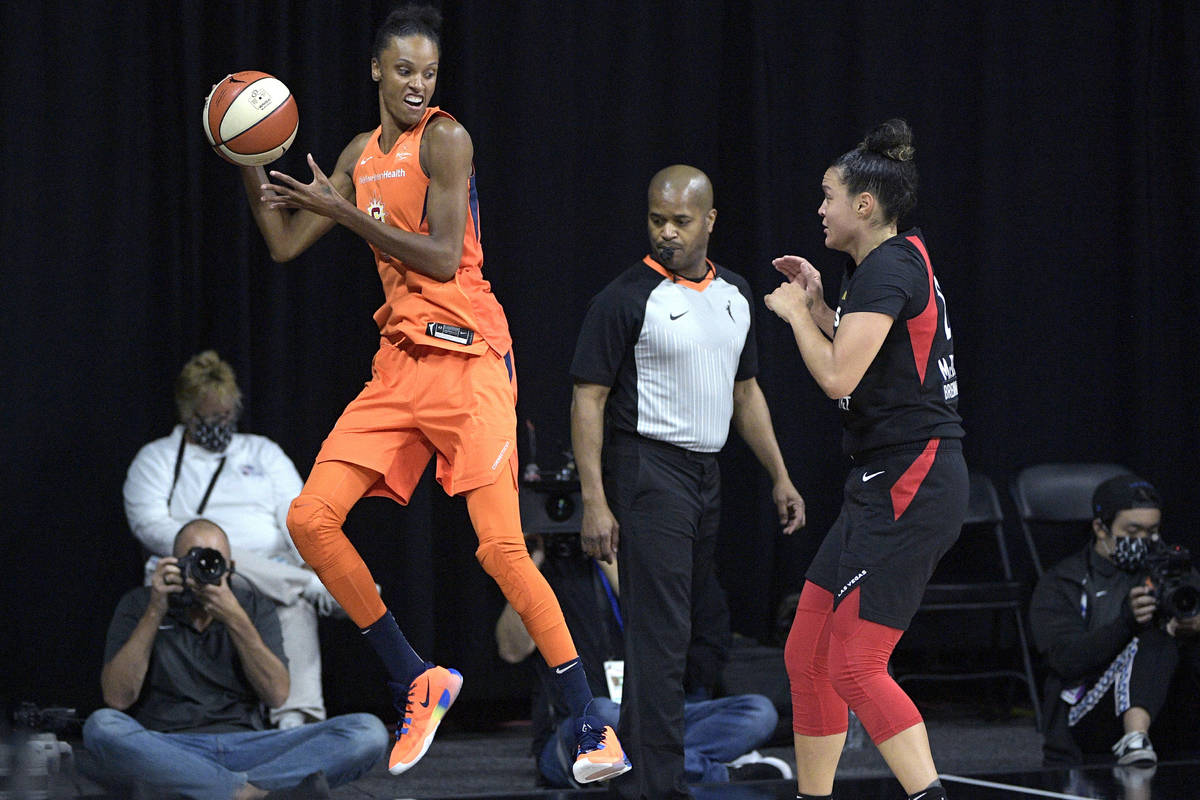 Connecticut Sun forward DeWanna Bonner, left, saves a loose ball from going out of bounds in fr ...