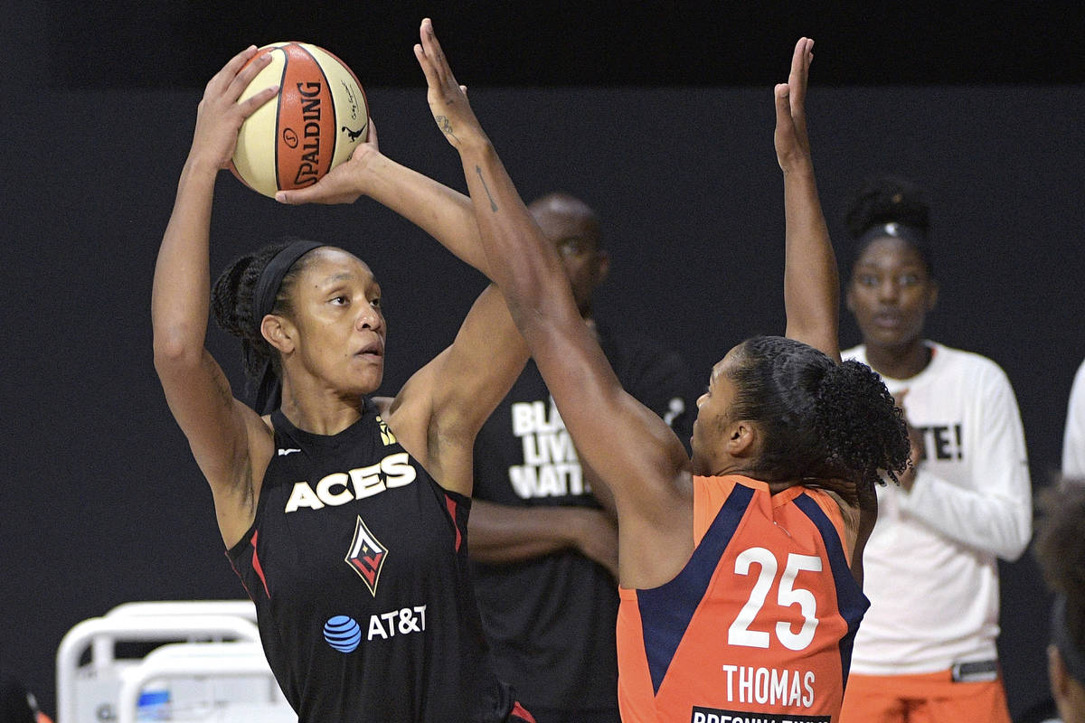 Las Vegas Aces center A'ja Wilson, left, goes up for a shot in front of Connecticut Sun forward ...
