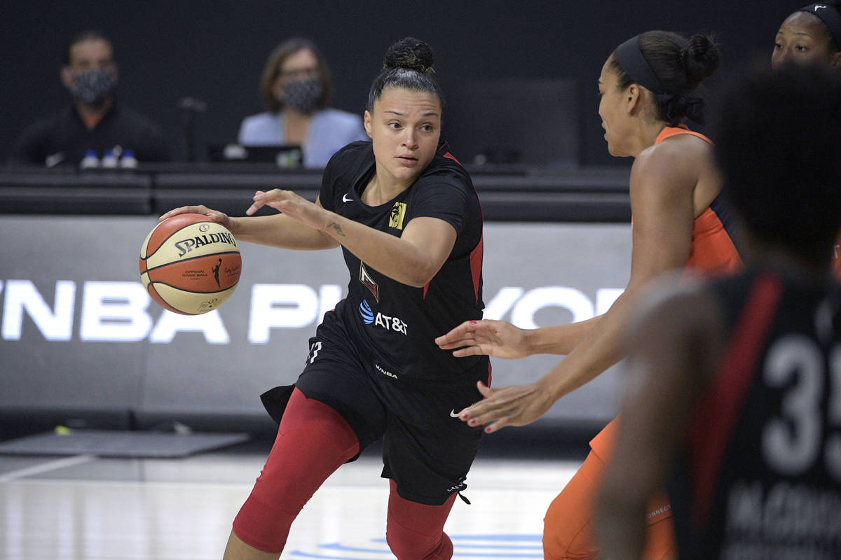 Las Vegas Aces guard Kayla McBride, left, drives to the basket in front of Connecticut Sun cent ...