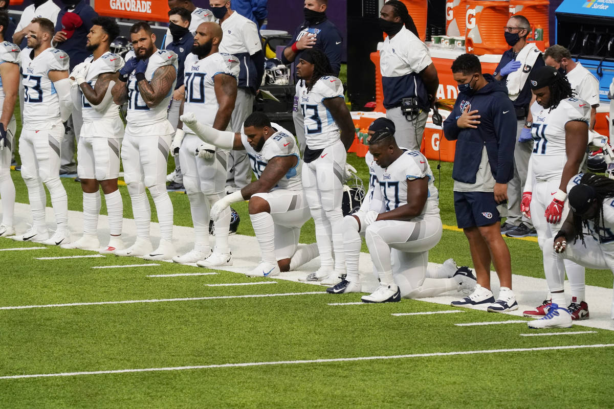 Members of the Tennessee Titans take part in the national anthem before an NFL football game ag ...