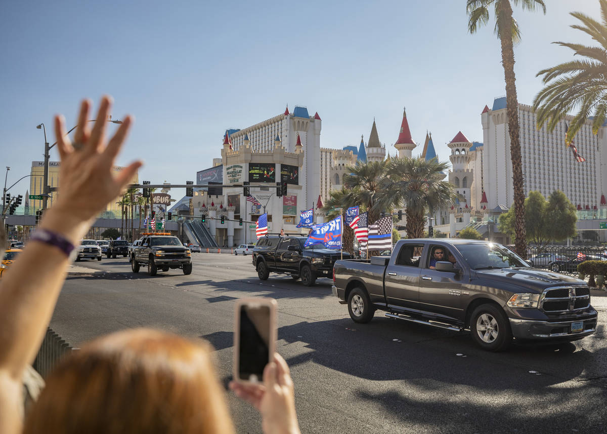 Individuals cheer as a caravan of Trump supporters ride down the Las Vegas Strip, on Wednesday, ...