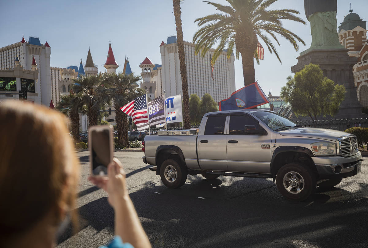 Individuals cheer as a caravan of Trump supporters ride down the Las Vegas Strip on Wednesday, ...