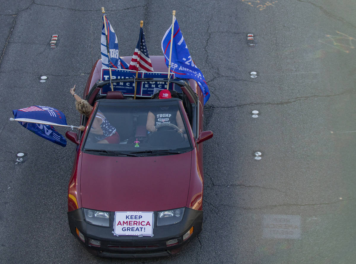 A car taking part in a caravan of Trump supporters, rides down the Las Vegas Strip, on Wednesda ...