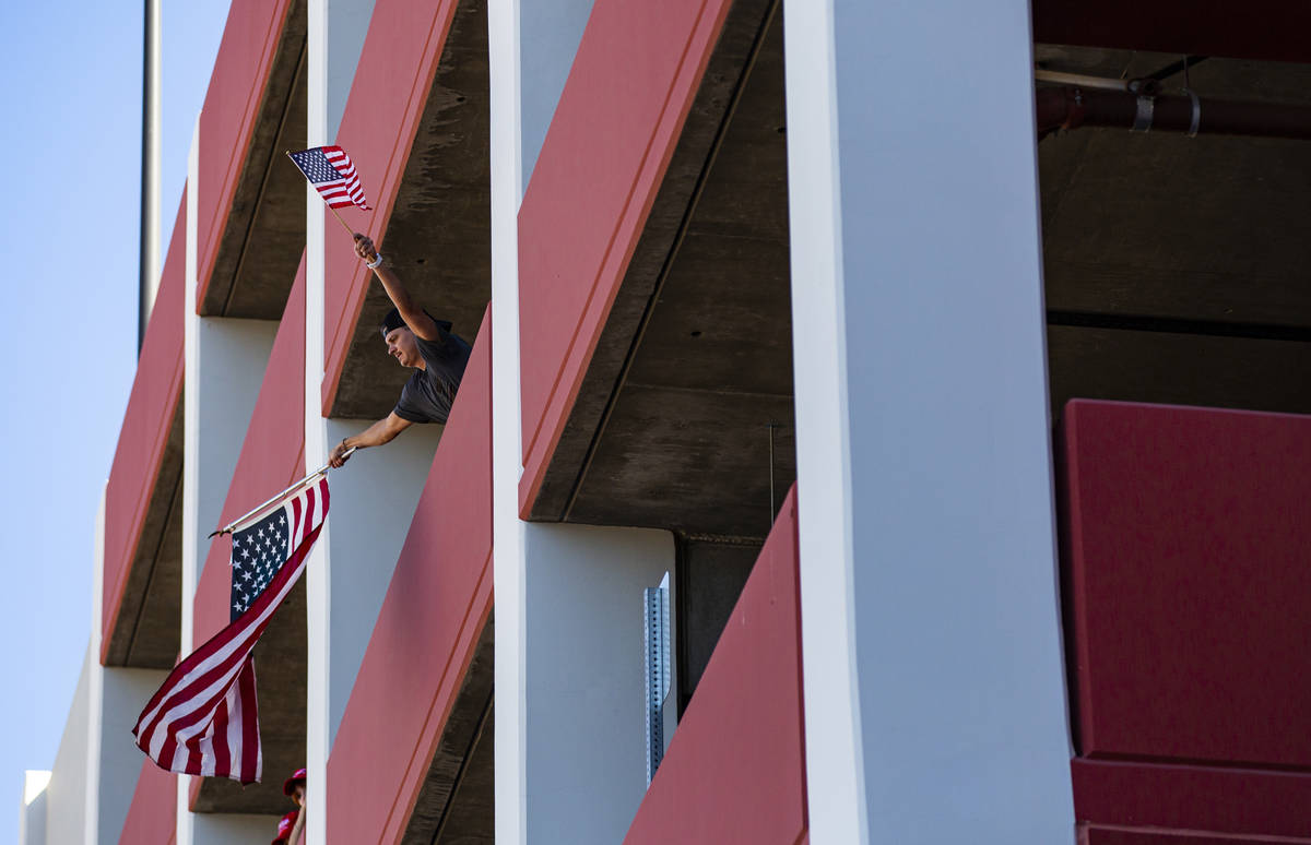 A man waves flags from the parking garage of the Ahern Hotel as supporters of law enforcement a ...