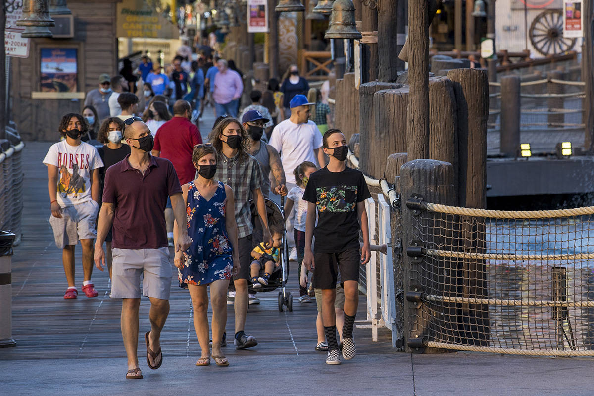 Visitors wander about Treasure Island along the Strip on Friday, August 7, 2020, in Las Vegas. ...