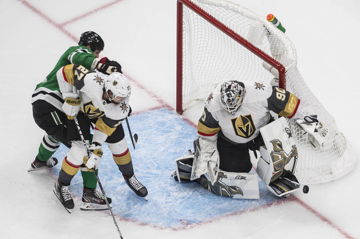 Dallas Stars' Jamie Benn and Vegas Golden Knights' Shea Theodore (27) work in front of Golden K ...
