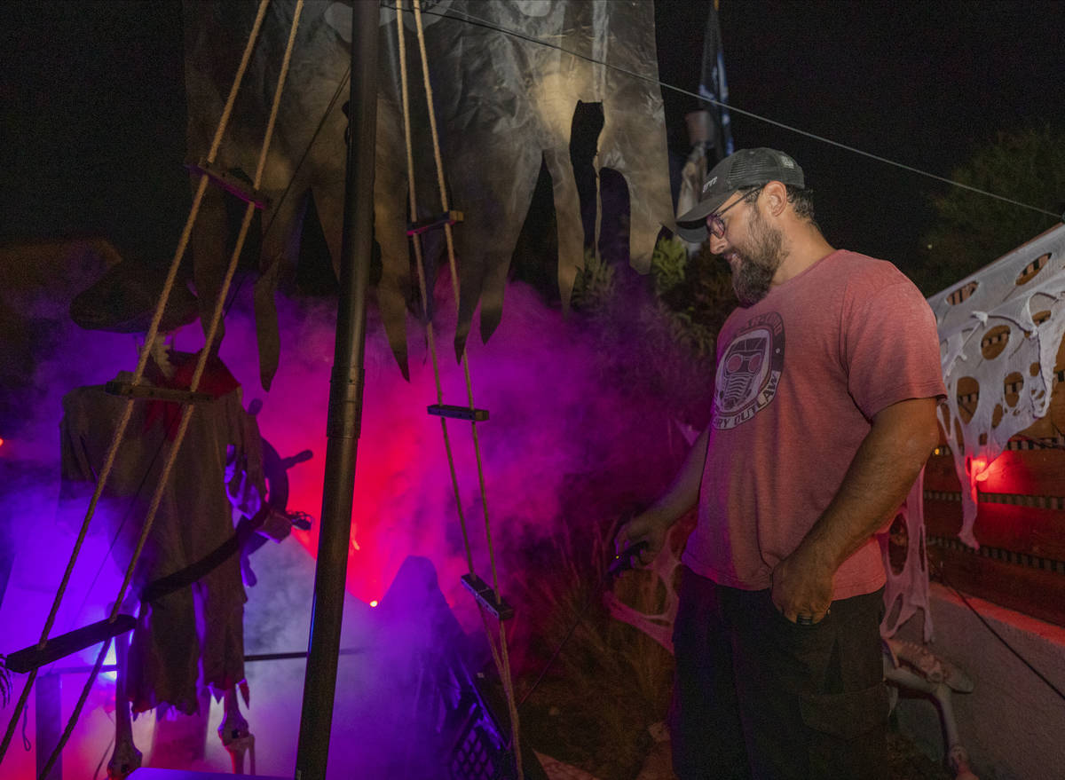 Leroy Garcia turns on the smoke machine in their backyard for their Disney-themed Halloween at ...