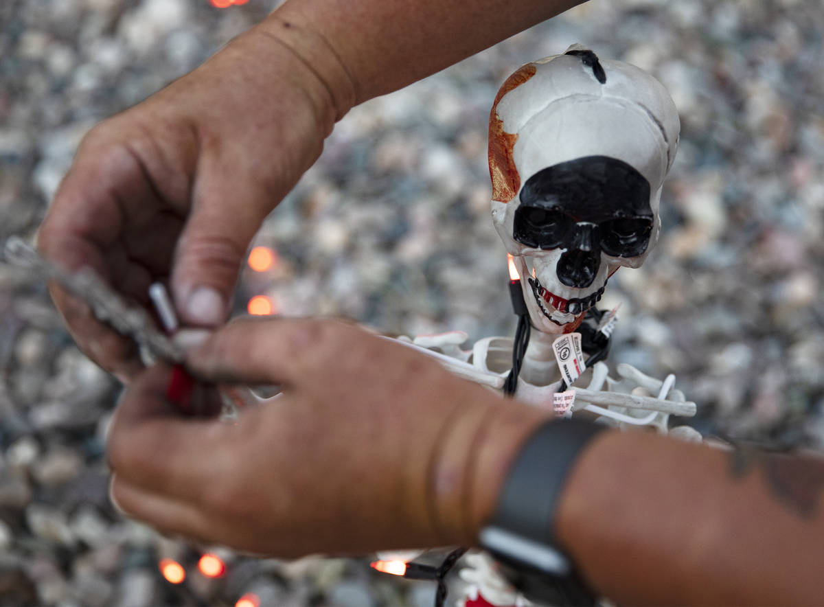 Tony Fronius adjusts a decorative skeleton in his front yard in Las Vegas, Sunday, Sept. 27, 20 ...