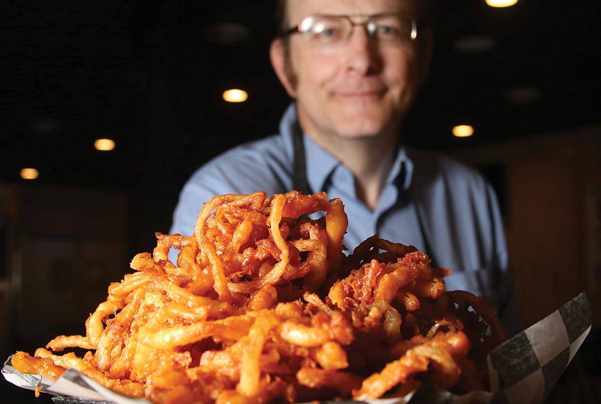 Larry Lang proudly holds up a plate of his onion rings. (Capp Bros. Productions)