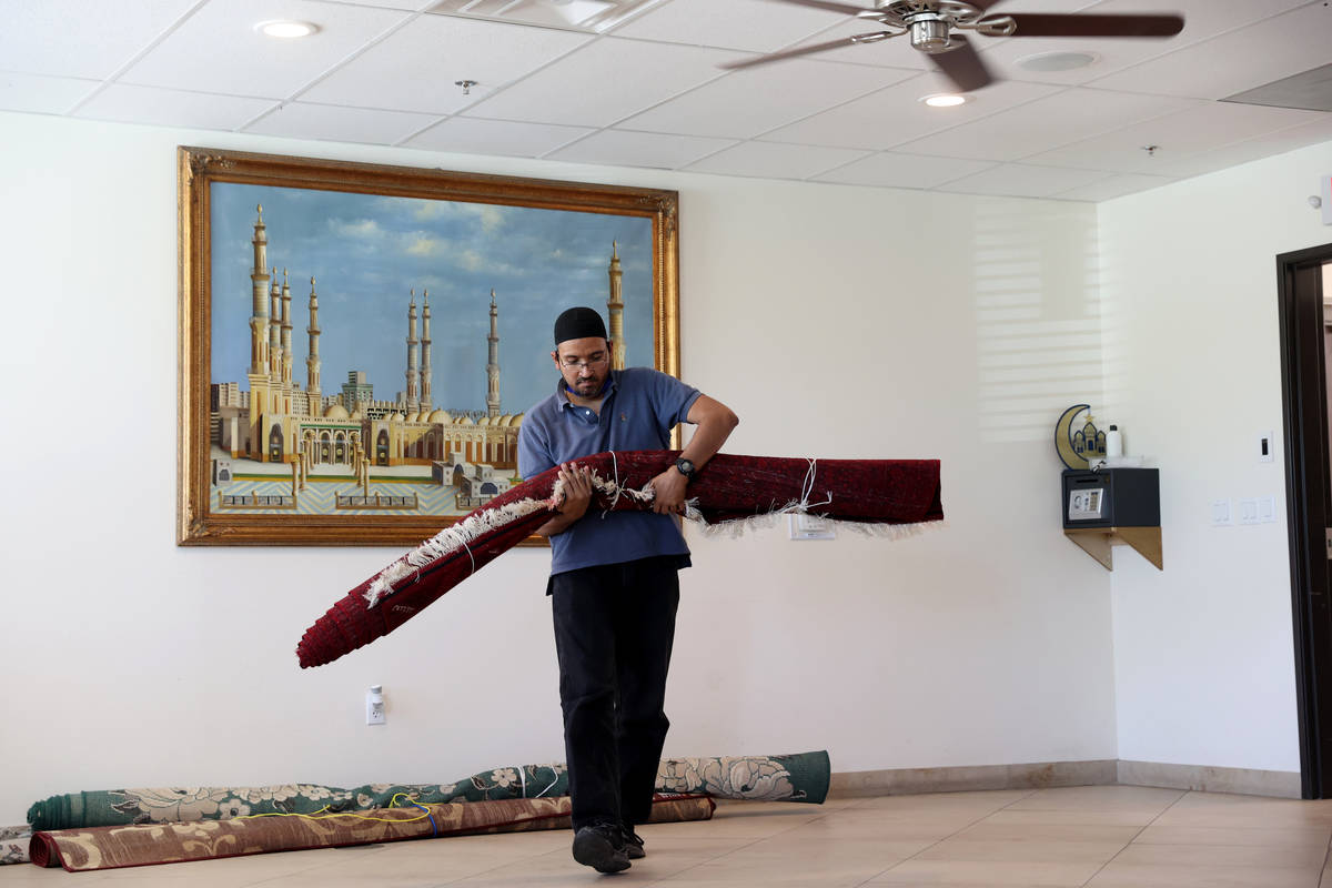 Shamsuddin Waheed, imam at Masjid Ibrahim in Las Vegas, prepares to place carpet in his social ...