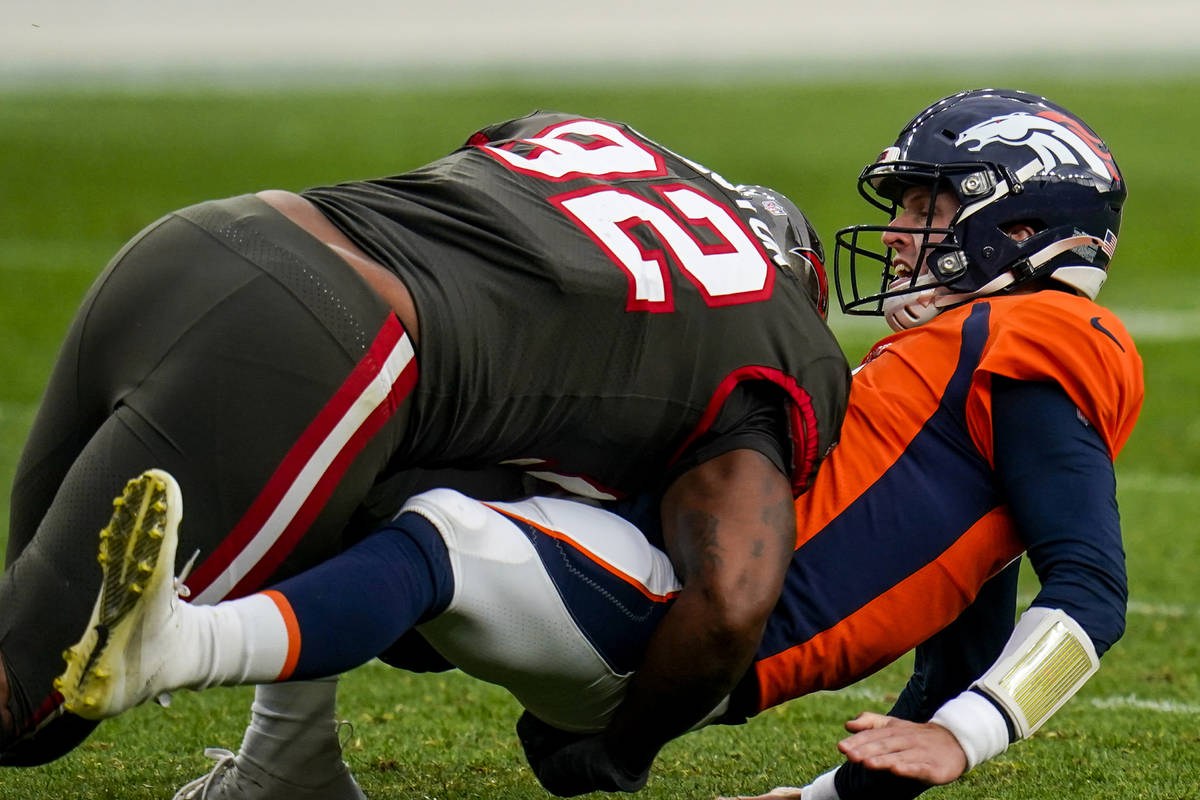 Denver Broncos quarterback Brett Rypien (4 is hit by Tampa Bay Buccaneers defensive end William ...