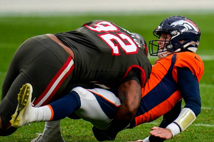 Denver Broncos quarterback Brett Rypien (4 is hit by Tampa Bay Buccaneers defensive end William ...
