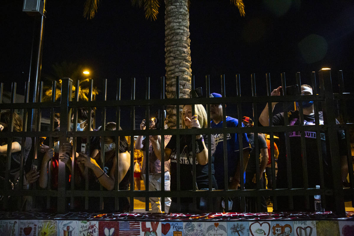 People watch as the names of the victims killed in the Route 91 Harvest festival shooting are r ...