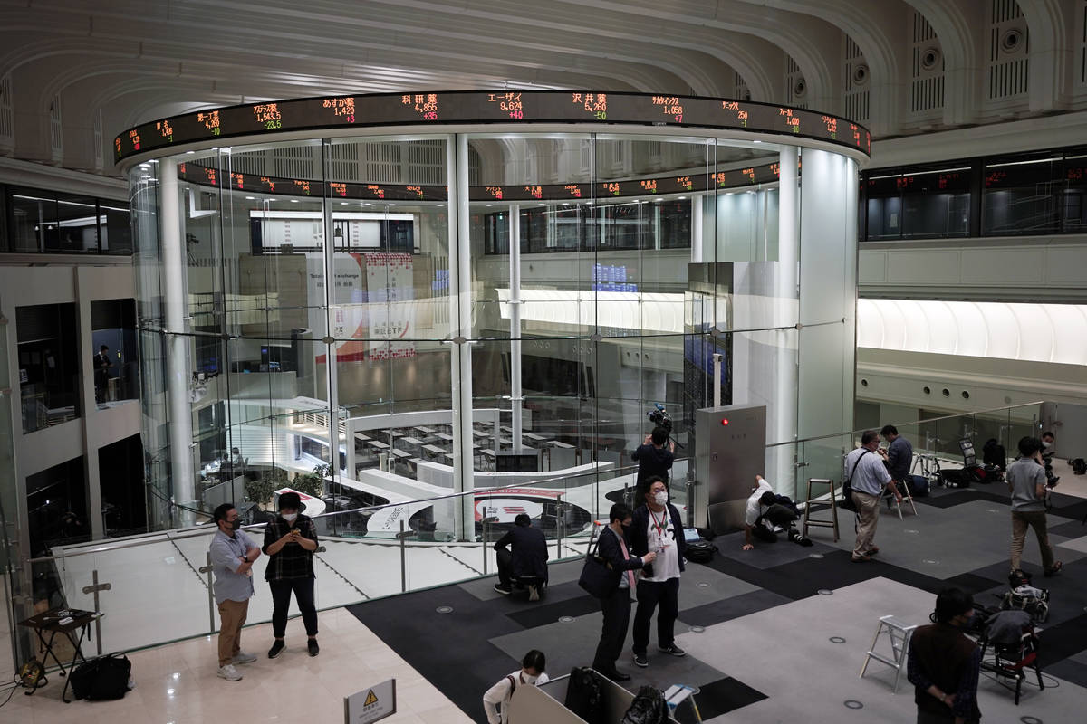 Journalists film an electronic stock board showing reopened Japan's Nikkei 225 index at Tokyo S ...