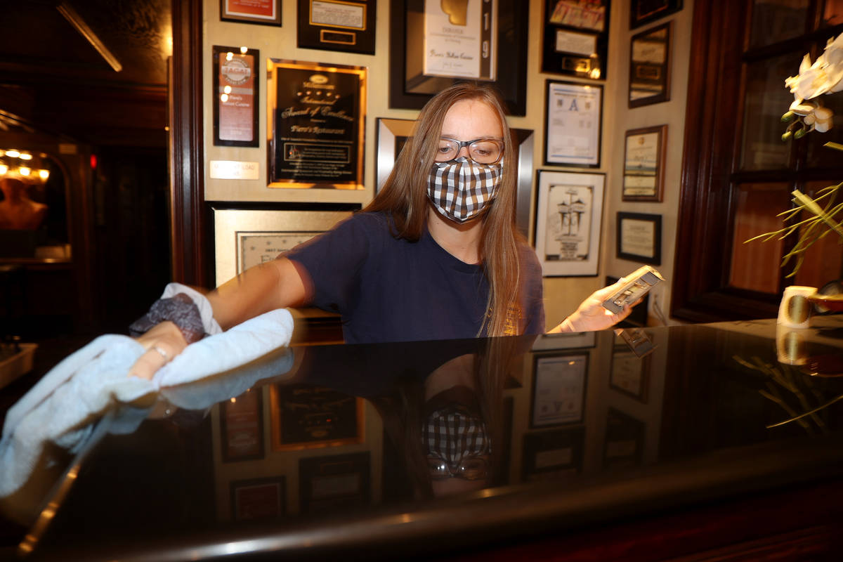 Hostess Rachel Fragoso cleans the welcome counter at Piero's Italian Cuisine in Las Vegas, Wedn ...