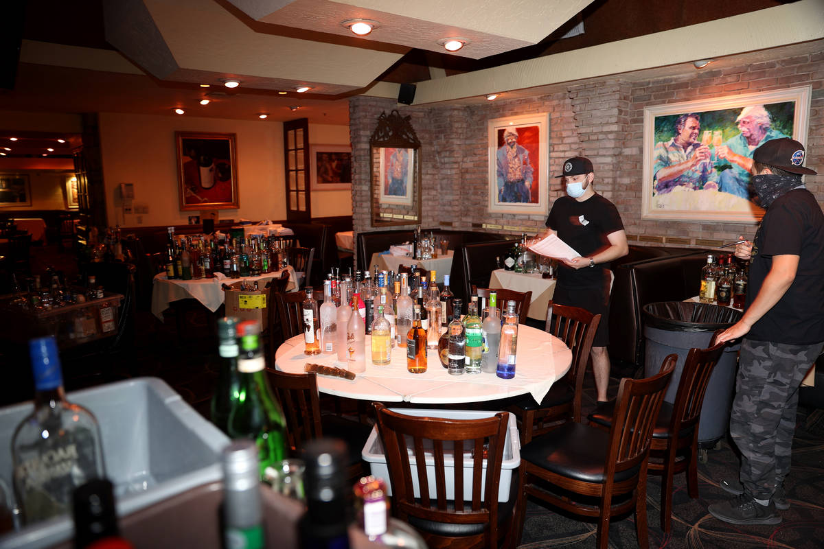 Bartenders Ryan Bruce, left, and Daniel Cenizeros, organize bottles for the bar ahead of the re ...