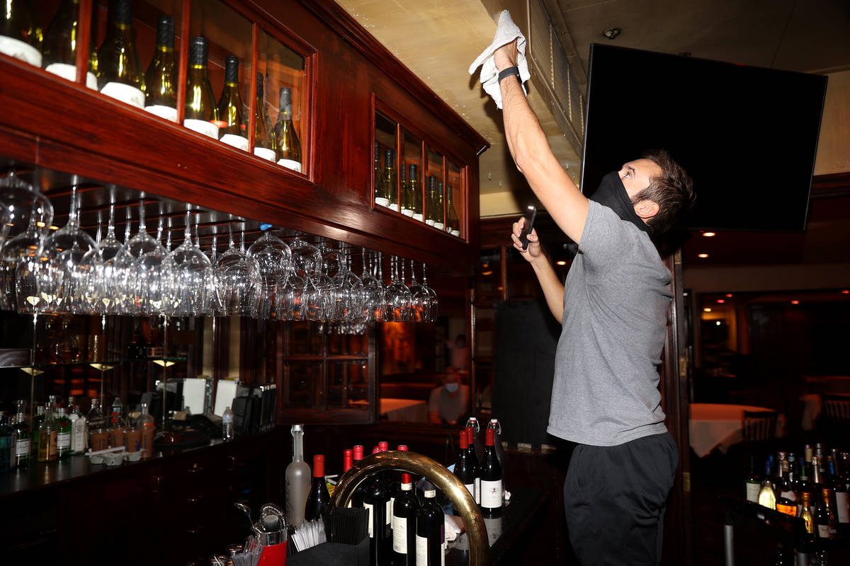 Server Joe Robinson cleans the bar in preparation of the reopening of Piero's Italian Cuisine i ...