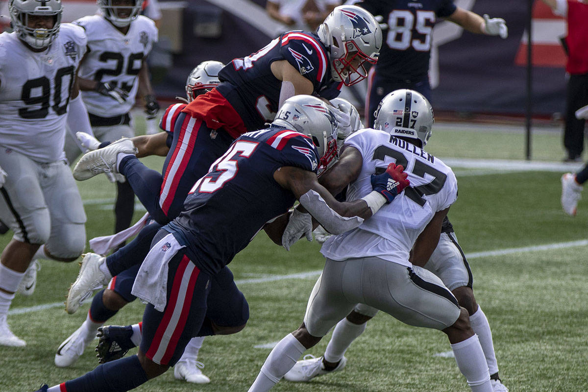 New England Patriots running back Rex Burkhead (34) leaps over Las Vegas Raiders cornerback Tra ...