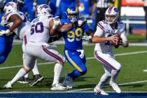 Buffalo Bills quarterback Josh Allen, right, avoids pressure by Los Angeles Rams defensive tack ...