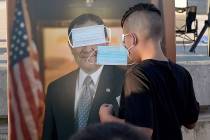 Children play "pin the mask on Gov. Gary Herbert" during a "Trash Your Mask Protest" rally host ...