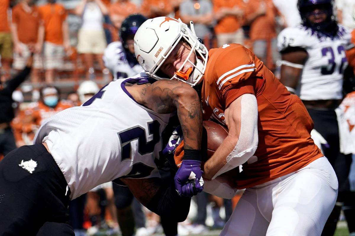 Texas wide receiver Jake Smith (7) is hit by TCU safety Ar'Darius Washington (24) as he makes a ...