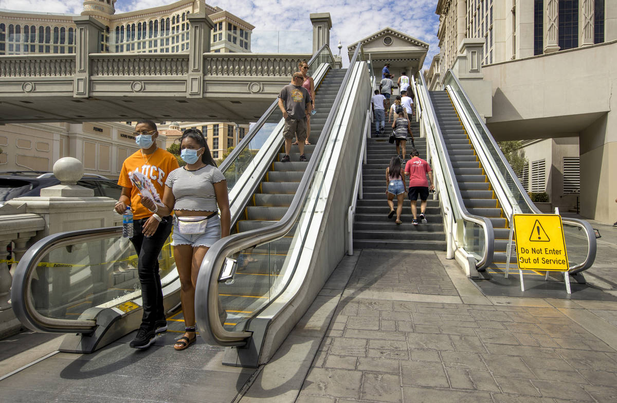 In this Sept. 5, 2020, file photo, pedestrians work their way down and up the bridge that cross ...