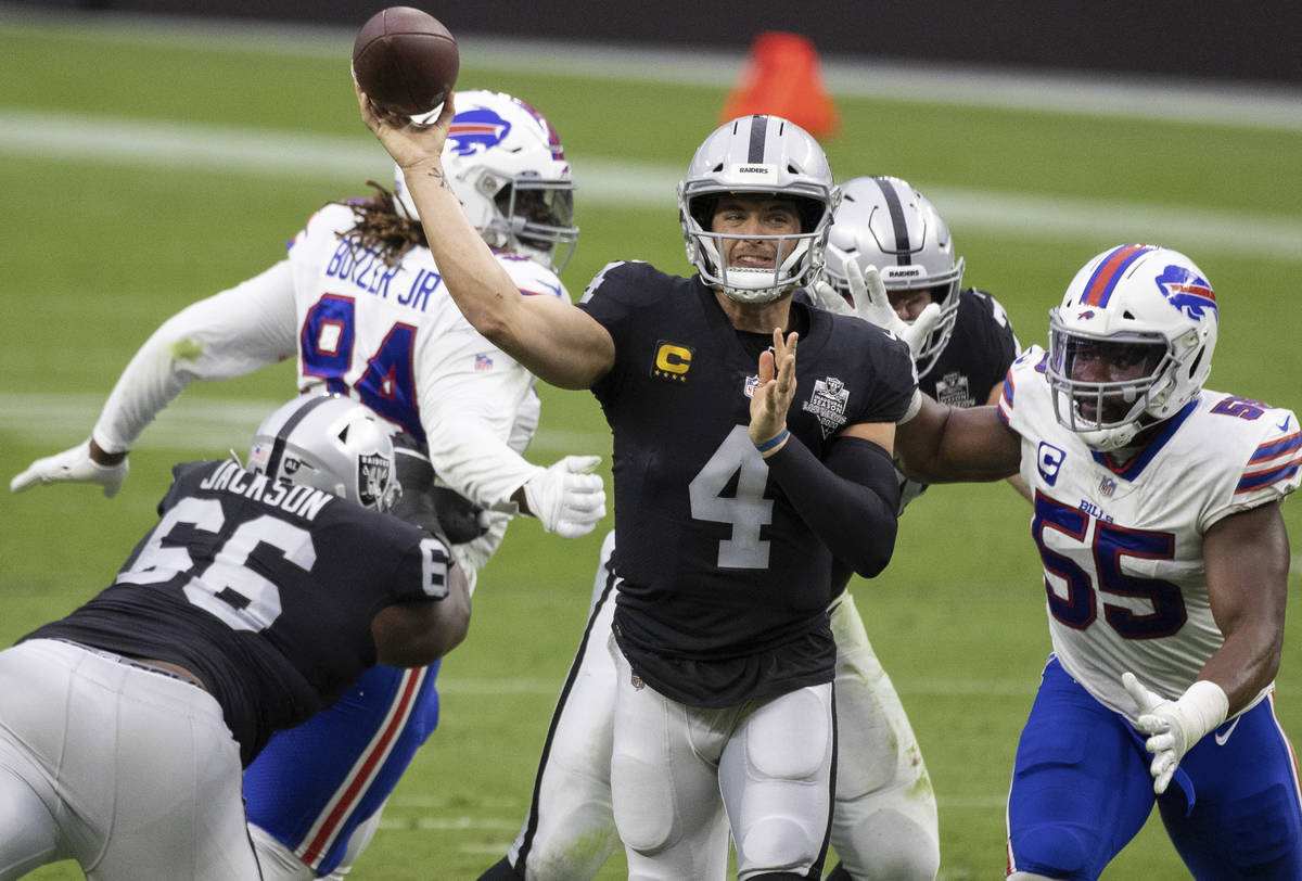 Las Vegas Raiders quarterback Derek Carr (4) just gets the ball away past Buffalo Bills defensi ...