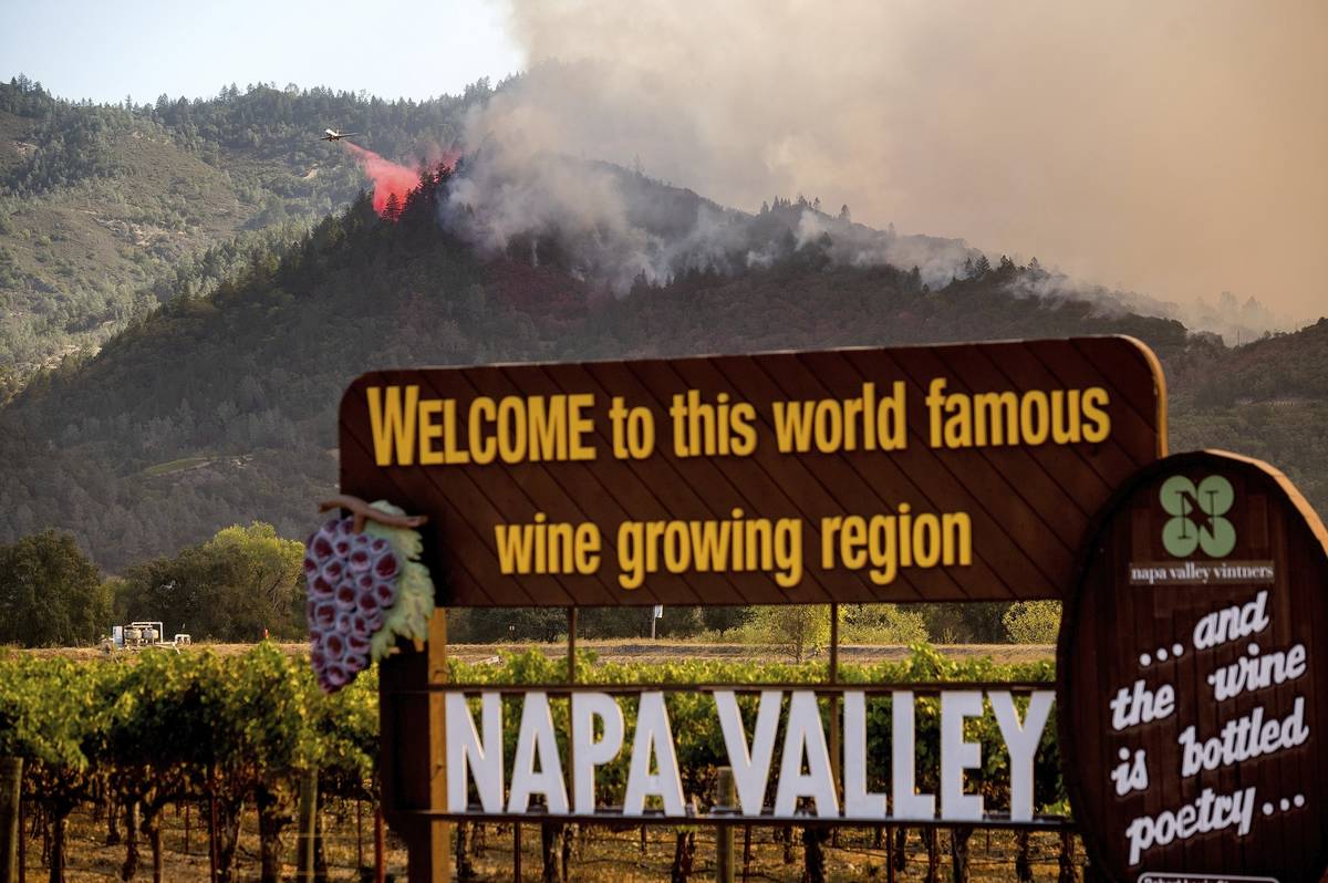 FILE - In this Sunday, Sept. 27, 2020, file photo, An air tanker drops retardant on the Glass F ...