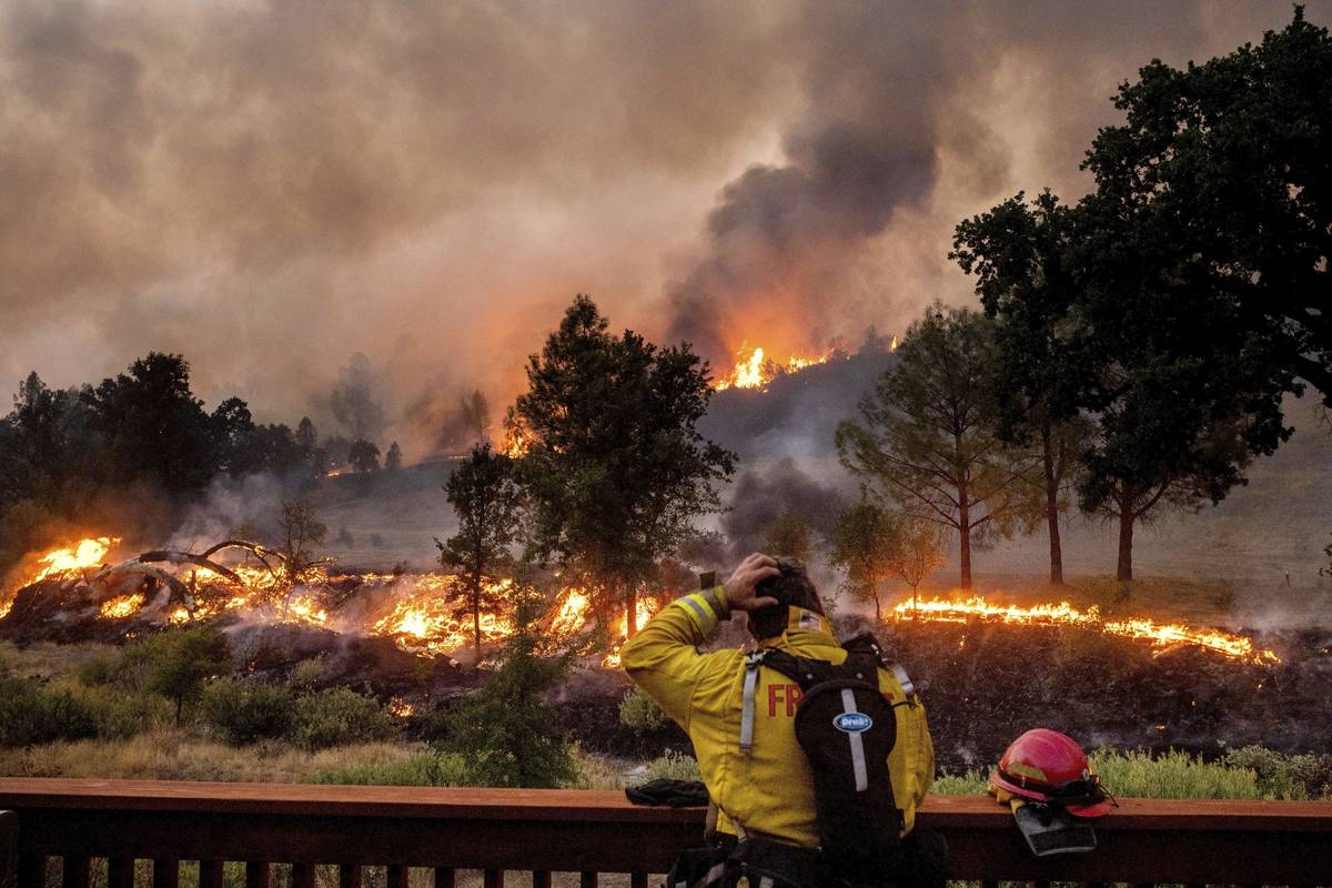 FILE - In this Aug. 21, 2020, file photo, a firefighter rubs his head while watching the LNU Li ...