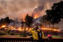 FILE - In this Aug. 21, 2020, file photo, a firefighter rubs his head while watching the LNU Li ...