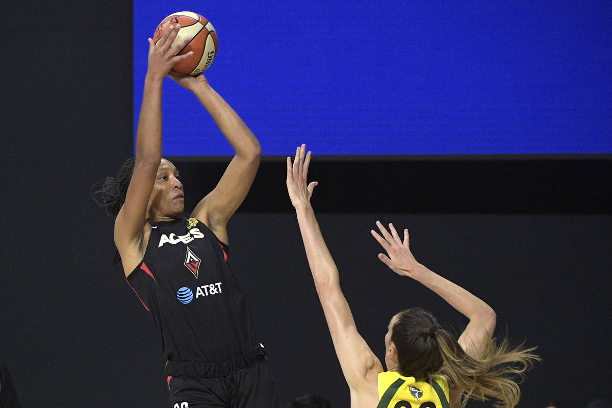 Las Vegas Aces center A'ja Wilson, left, goes up to shoot in front of Seattle Storm forward Bre ...