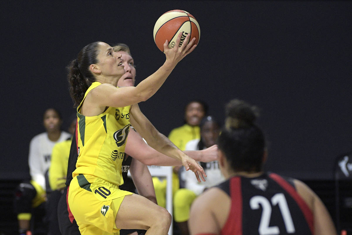 Seattle Storm guard Sue Bird (10) goes up to shoot between Las Vegas Aces center Carolyn Swords ...