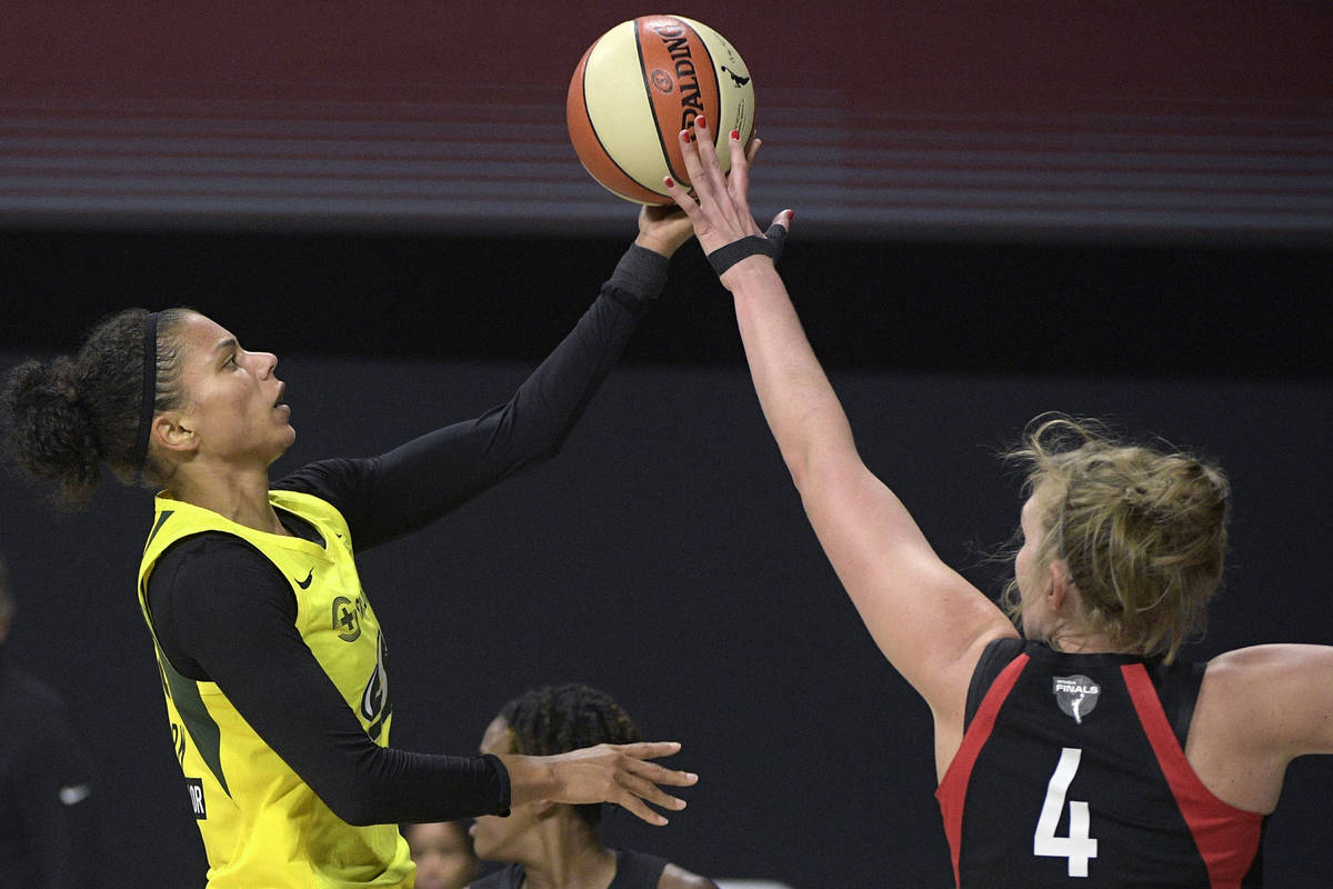 Seattle Storm forward Alysha Clark, left, goes up to shoot in front of Las Vegas Aces center Ca ...