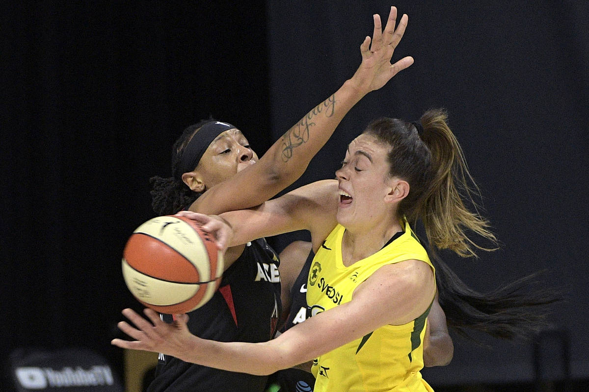Seattle Storm forward Breanna Stewart, right, passes the ball while defended by Las Vegas Aces ...