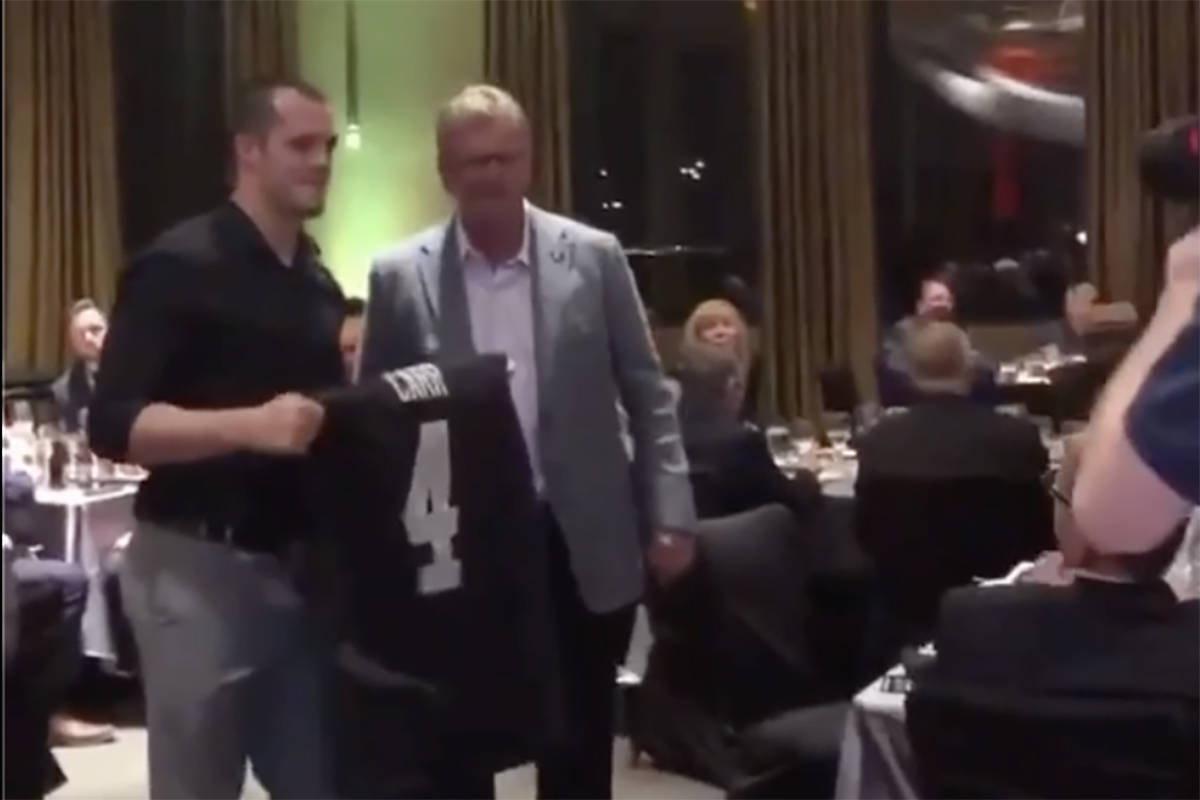 Raiders quarterback Derek Carr is seen posing with a fan at at gala for Darren Waller's foundat ...