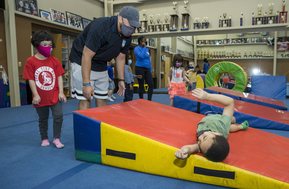 Instructor Mo Bonnet, center, assists kindergartener Kayden Rush, right, in a hotdog roll as Am ...