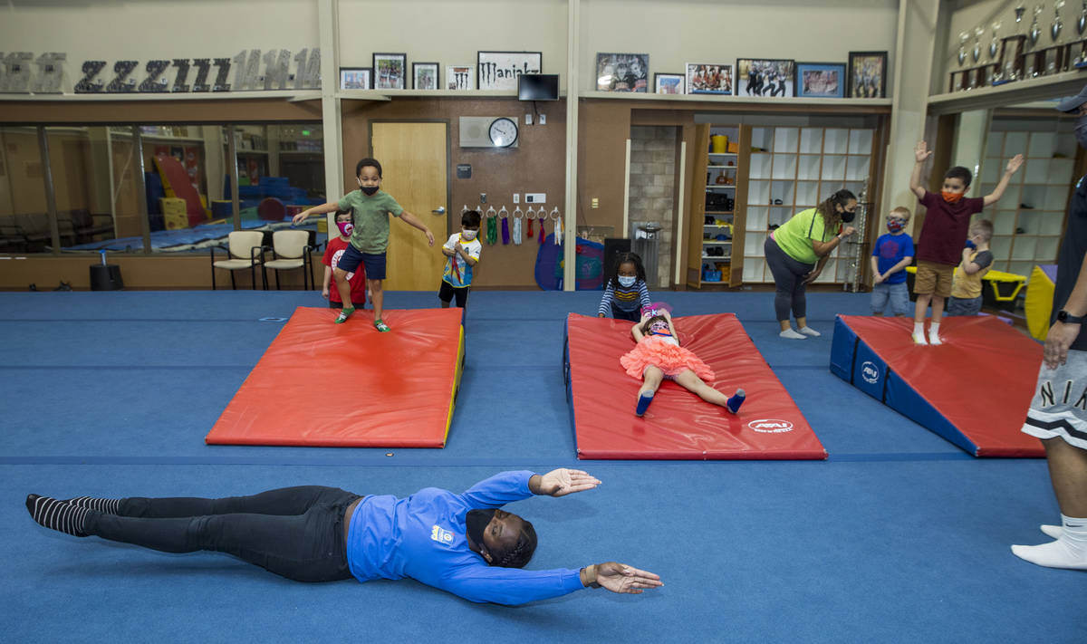 Instructor Iviana Ridgeway, below, shows kindergarteners a hotdog roll as their next exercise d ...