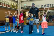 Instructor Mo Bonnet, center, encourages kindergarteners in standing jumps while exercising dur ...