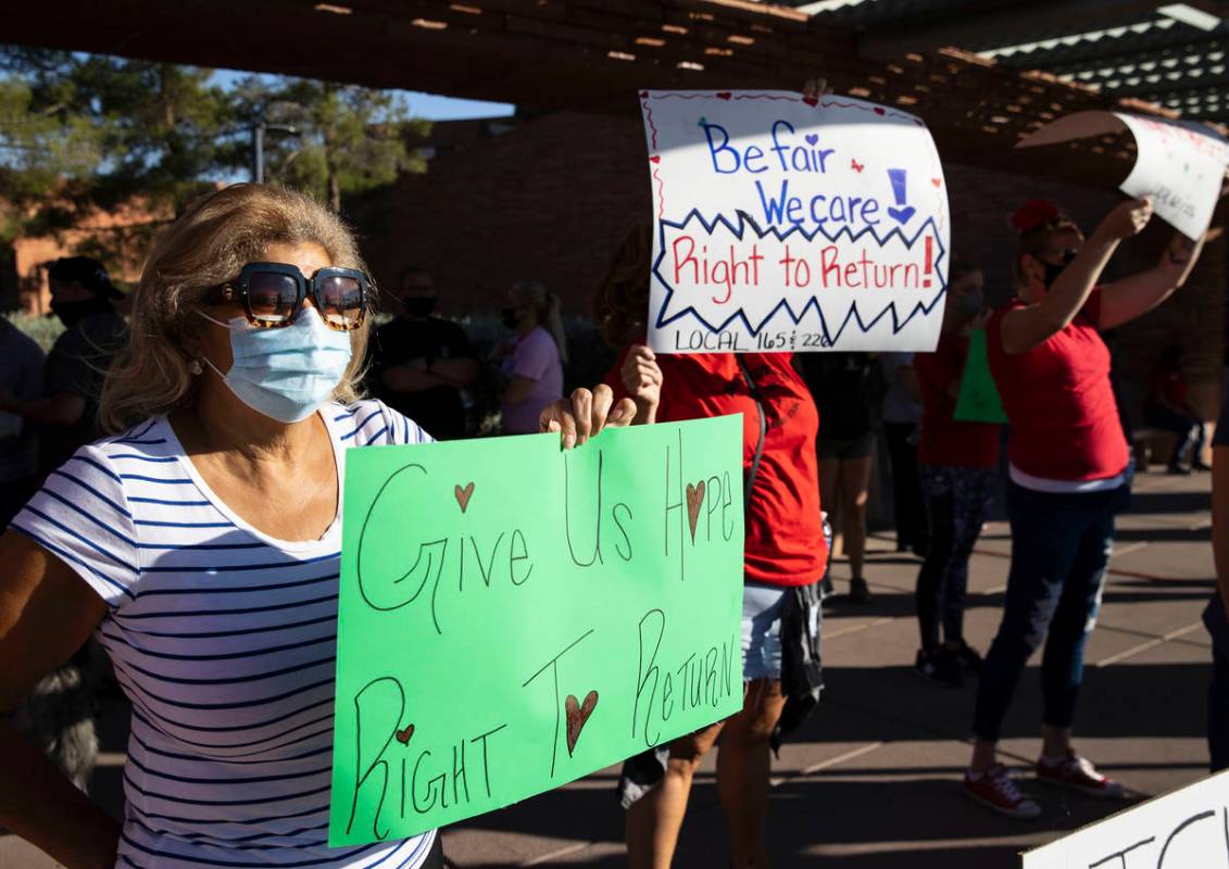 Reina Almuina, a waitress at Aria, holds a sign as she joins a rally outside of the Clark Count ...